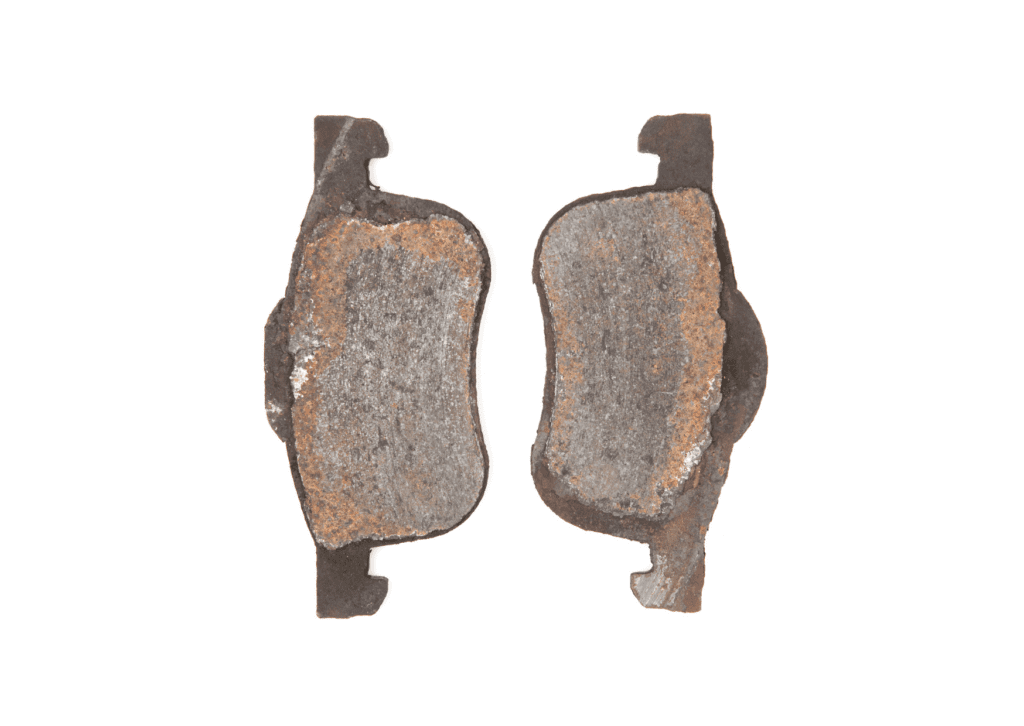 Severely worn and rusted brake pads, showing clear signs to replace brake pads for vehicle safety and performance