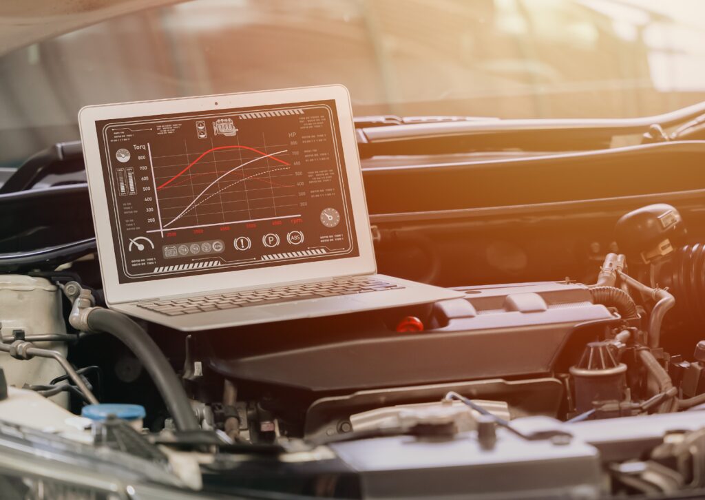 Mechanic inspecting a car engine with a clipboard, demonstrating what is a tune-up for vehicle maintenance.