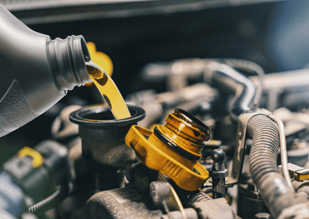 Engine oil being poured into a car engine with an open oil cap, showing maintenance and lubrication process.