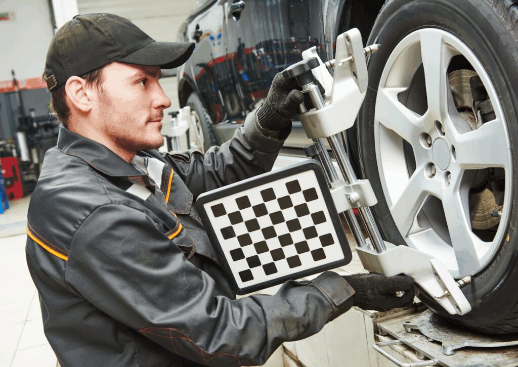 Car on lift with sensors and reflectors mounted on wheels during a computerized wheel alignment check.