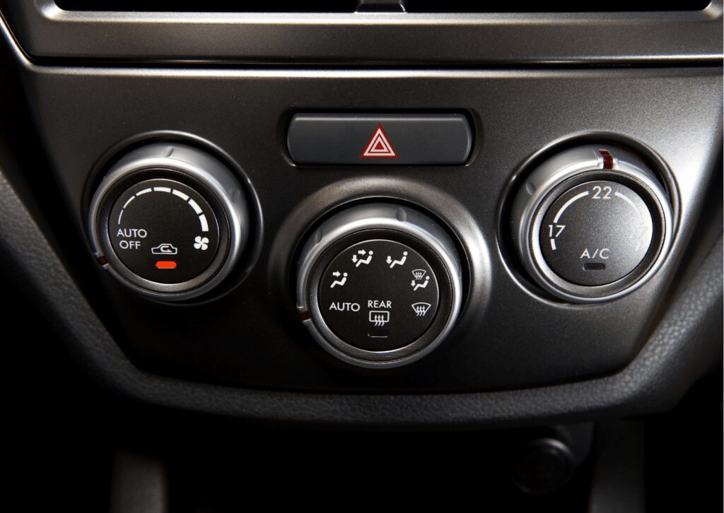 Close-up of modern car dashboard controls showing fan speed, air flow direction, and temperature.