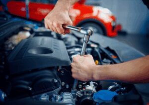 A mechanic using a socket wrench on engine components during professional car engine repair services.