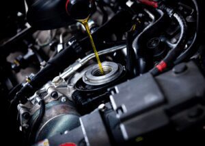 Motor oil being poured into engine during service, highlighting maintenance and how many kms between oil changes.