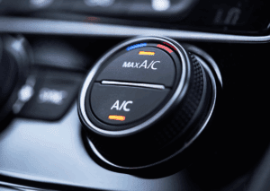 Close-up of a car climate control system dial showing A/C and Max A/C temperature adjustment settings.