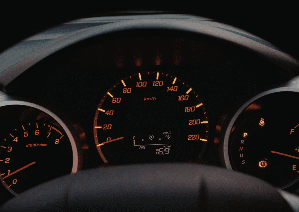 Mechanic in blue gloves uses an impact wrench to tighten lug nuts on an alloy wheel during tire service.
