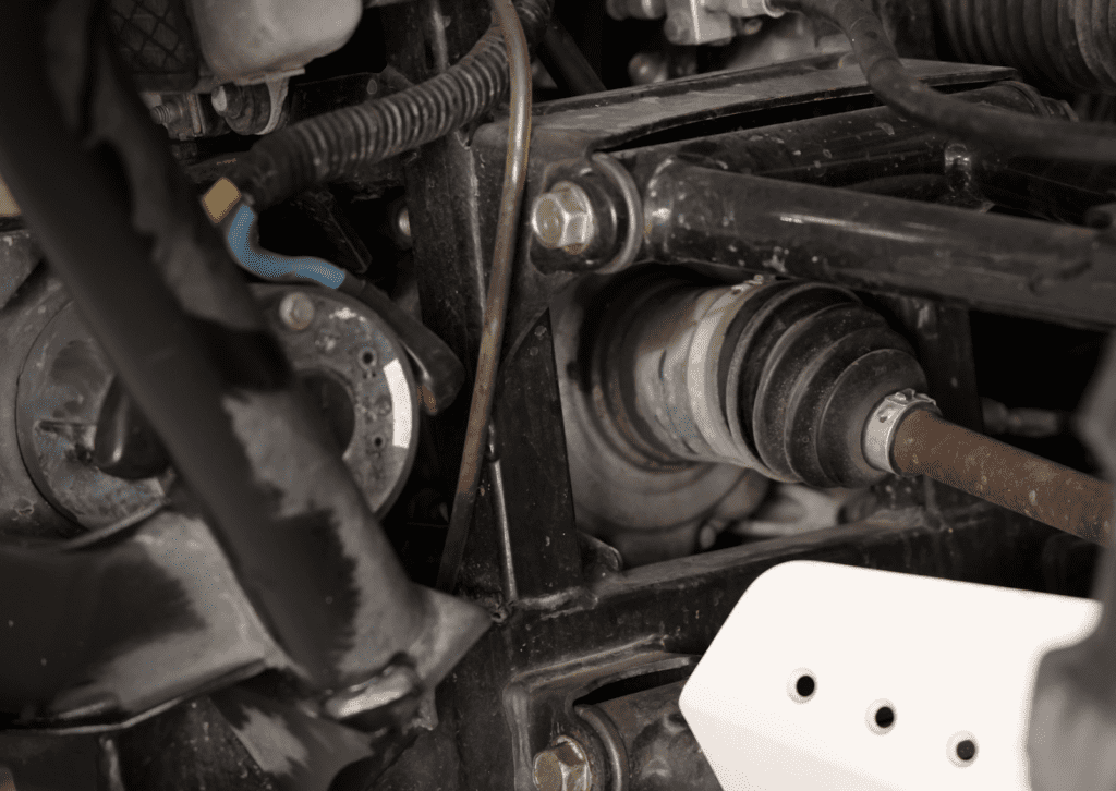 Close-up of axle and suspension parts that may contribute to car suspension noises during inspection.
