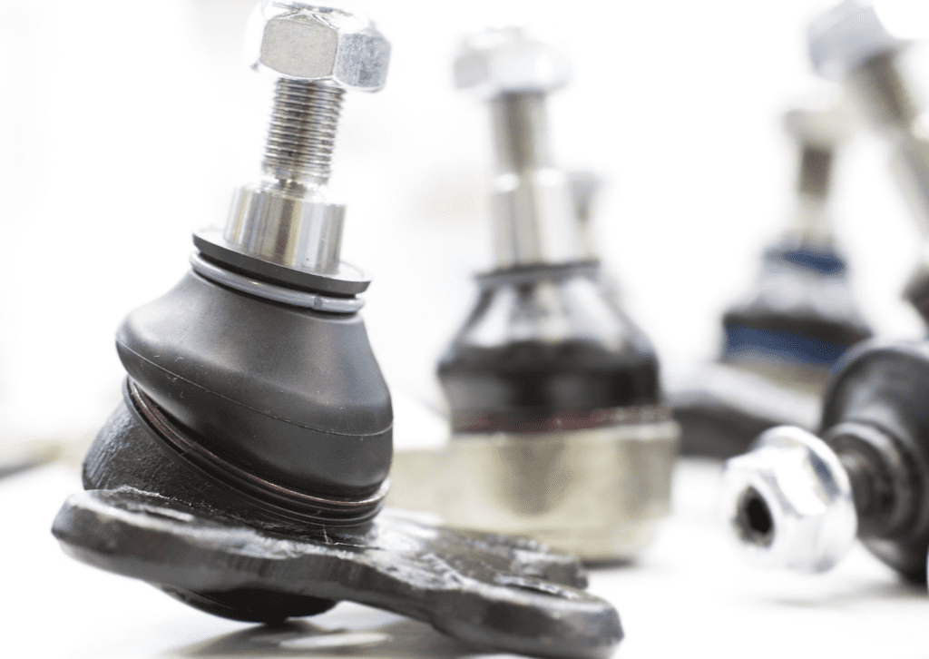 Close-up of new suspension ball joints and tie rod ends arranged for steering repair service.