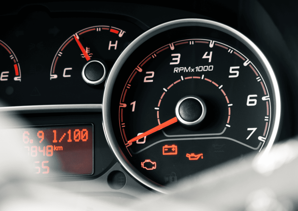 Dashboard gauges display check engine, battery, and oil warning lights with coolant temp meter.