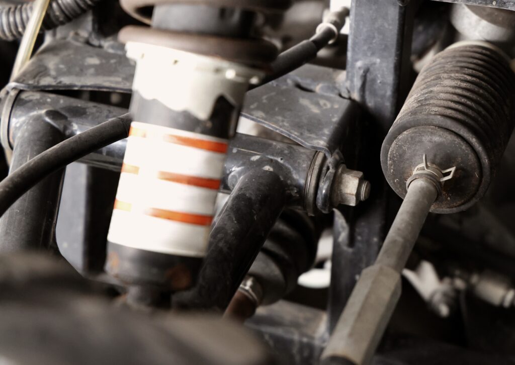 Close-up of suspension shock, tie rod and steering linkage inside vehicle wheel assembly area view.