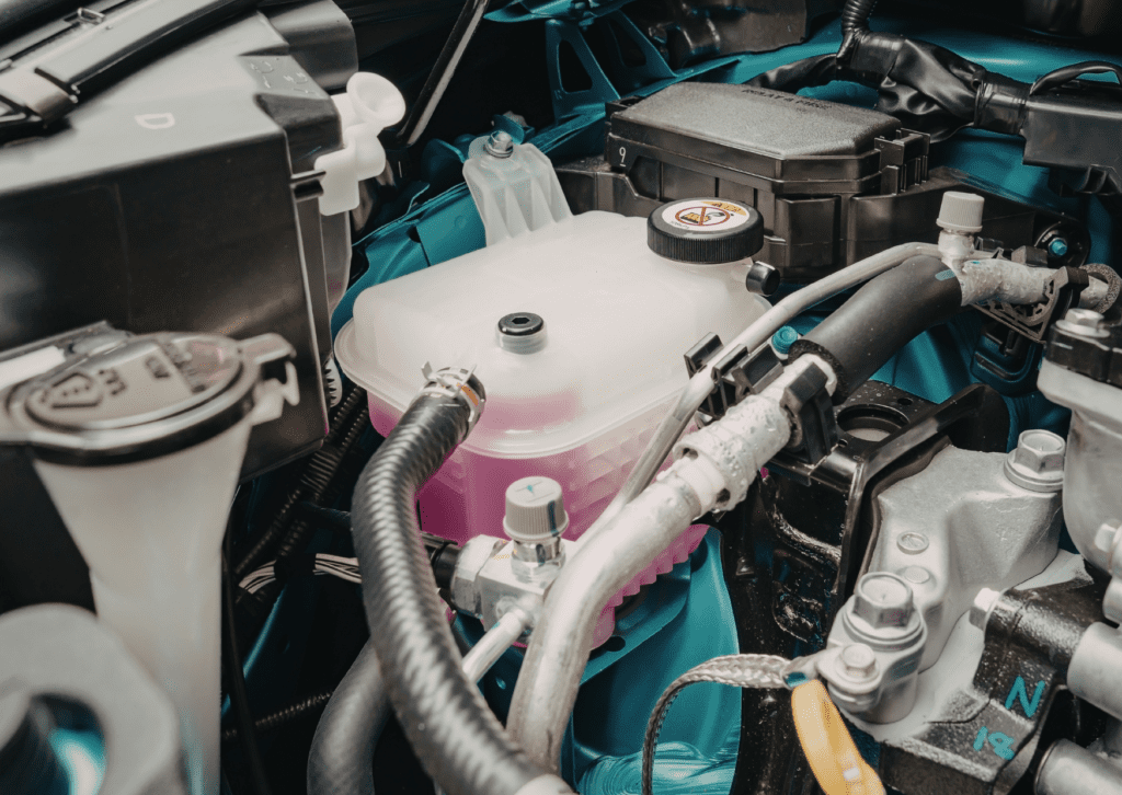 Engine bay coolant reservoir with pink fluid, checking car leaking fluid when parked issue 