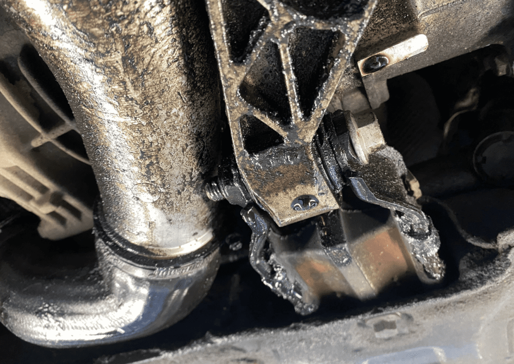 Oil-soaked undercarriage showing car leaking fluid when parked from engine or transmission area 