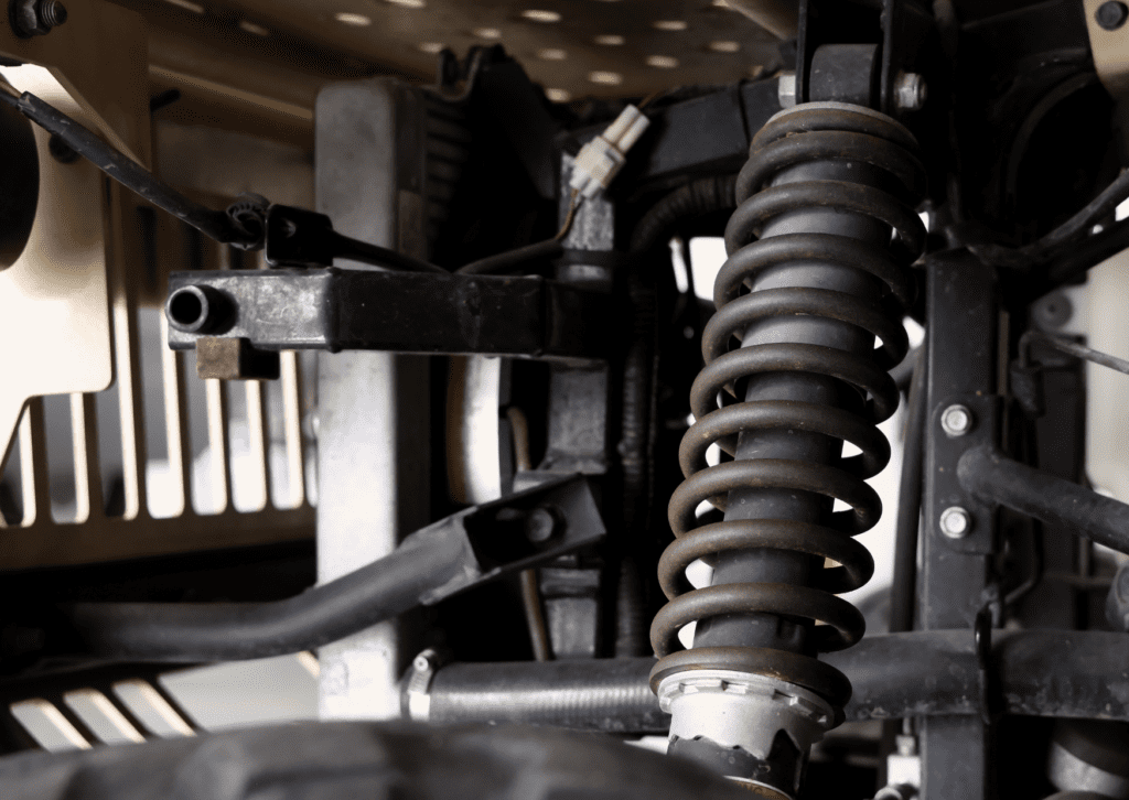 Vehicle coil spring, shock absorber, and suspension frame components shown beneath the car 