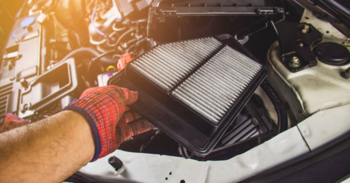 Car air filter in a hand of mechanic man is installing into air filter socket of car engine,Automotive part concept.
