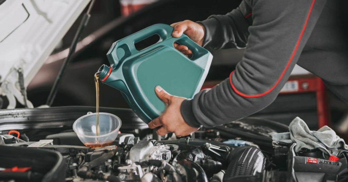 Pouring oil to car engine.